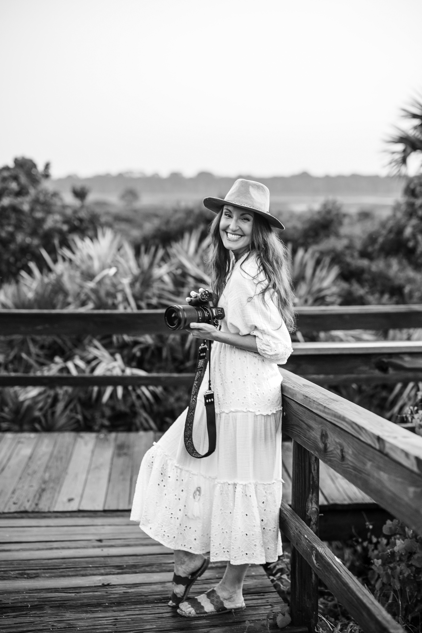 Jacksonville photographer portrait of herself holding camera during sunset beach branding session at Ponte Vedra Beach