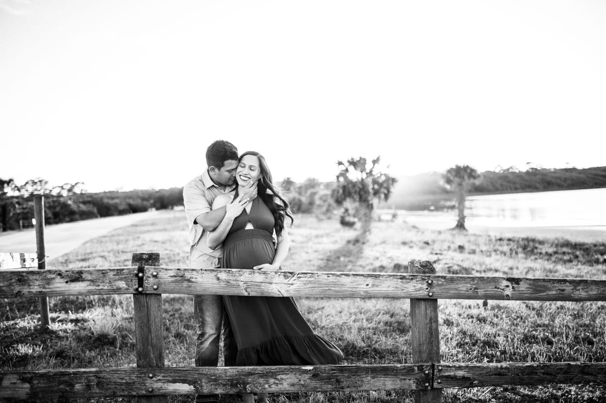 mom and dad to be embracing pregnancy during sunset in Ponte Vedra Beach during their maternity shoot by Jacksonville photographer