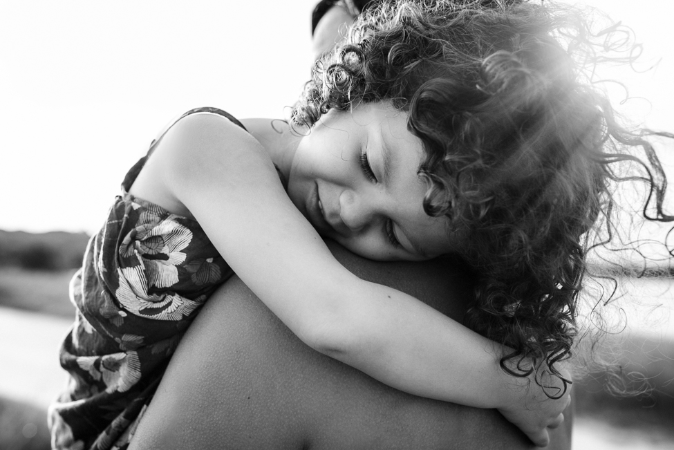 mom and her child hugging in sunset | jacksonville family photographer