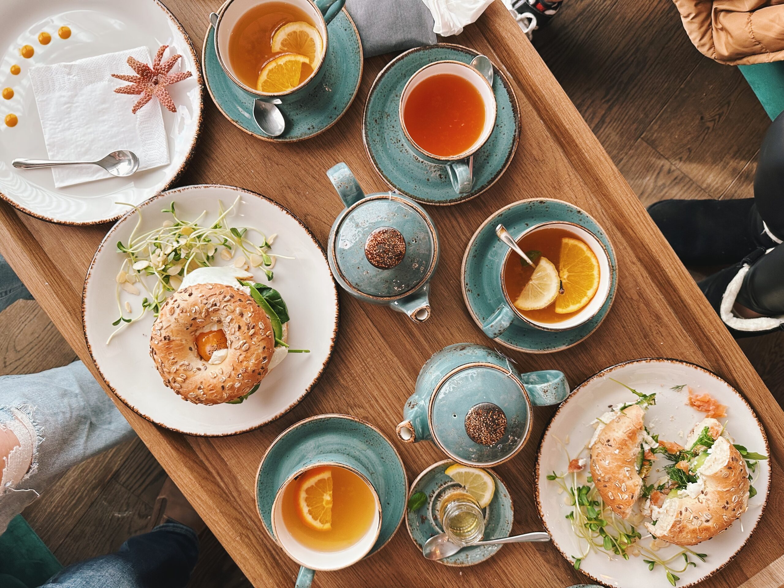 colorful capture of table filled with brunch dishes, bagels and beautiful tea set