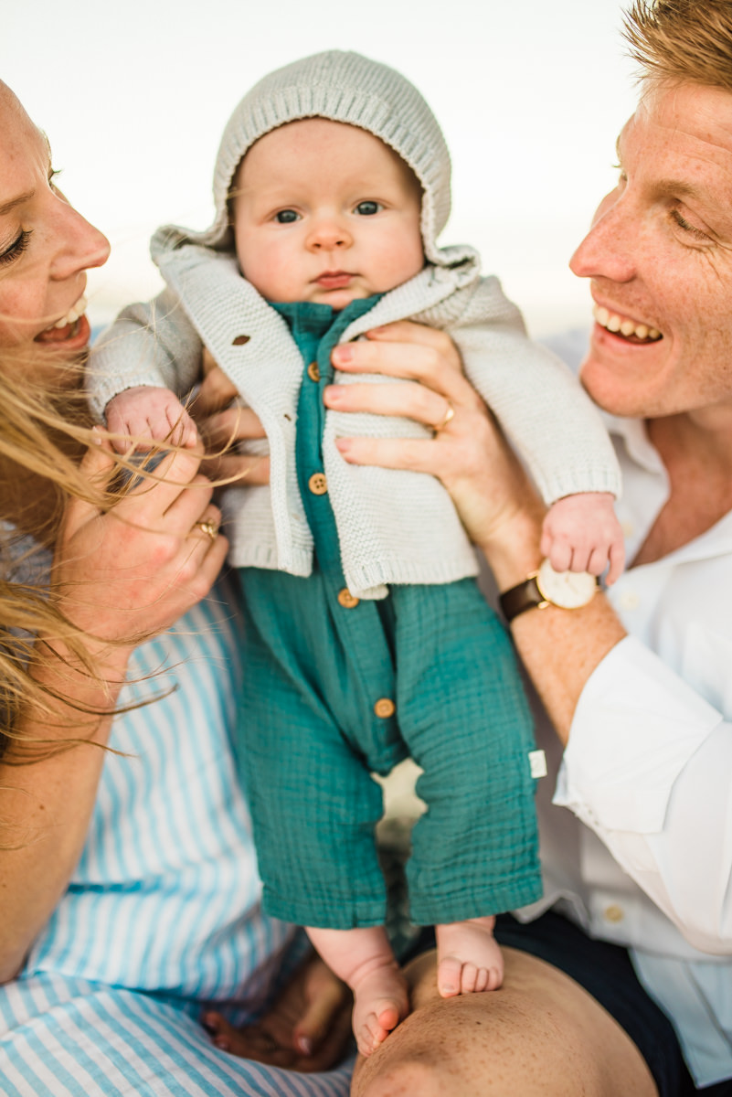 parents holding baby in between them in a Jacksonville children's photoshoot