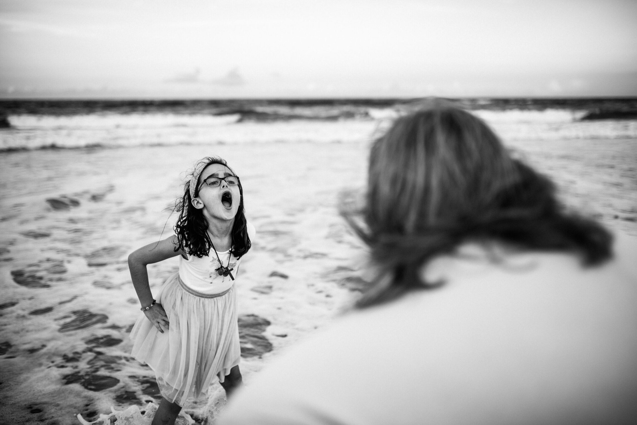 young girl laying on the beach shore in a Jacksonville children's photoshoot