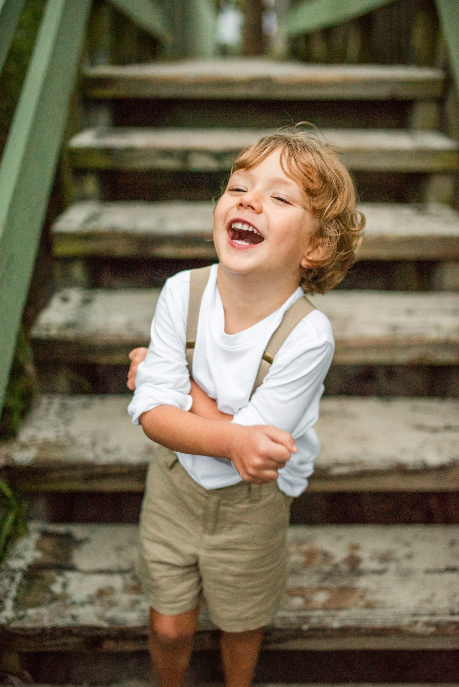 young boy laughing on the steps in a Jacksonville children's photoshoot