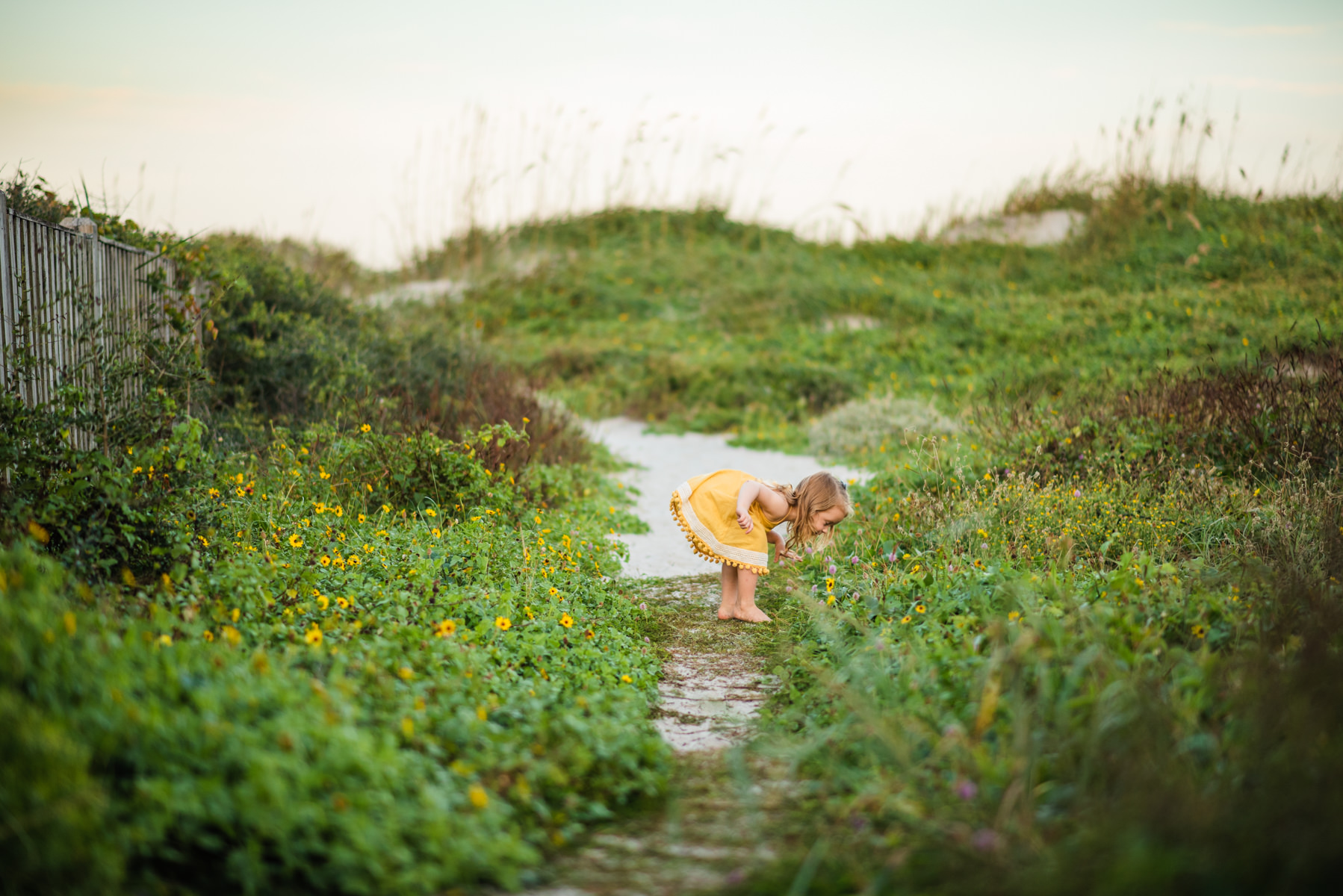 young girl smelling flowers in a Jacksonville children's photoshoot