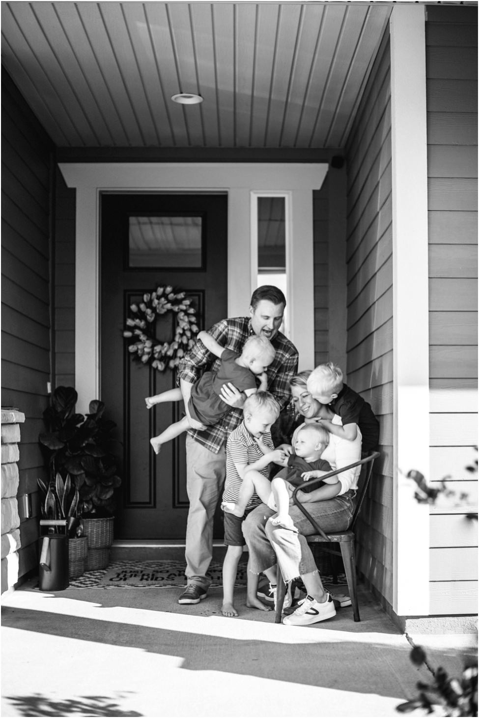 Parents and small children laughing and playing climbing on mother in a family photoshoot in Jacksonville FL