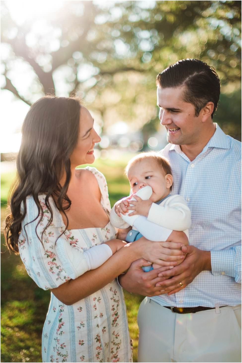 Parents smiling at each other holding their baby in a family photoshoot in Jacksonville FL