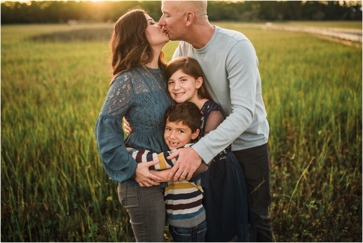 Parents and children posing for photos with parents kissing and children hugging them in family photoshoot in Jacksonville FL
