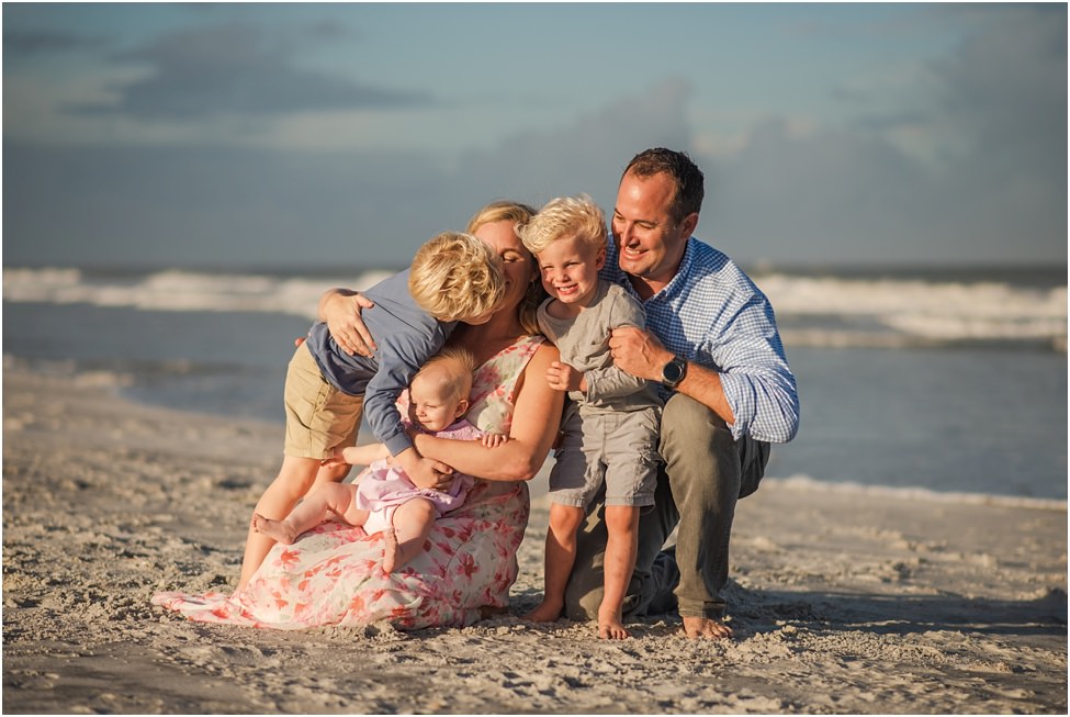 Parents and three children hugging and laughing in a family photoshoot in Jacksonville FL