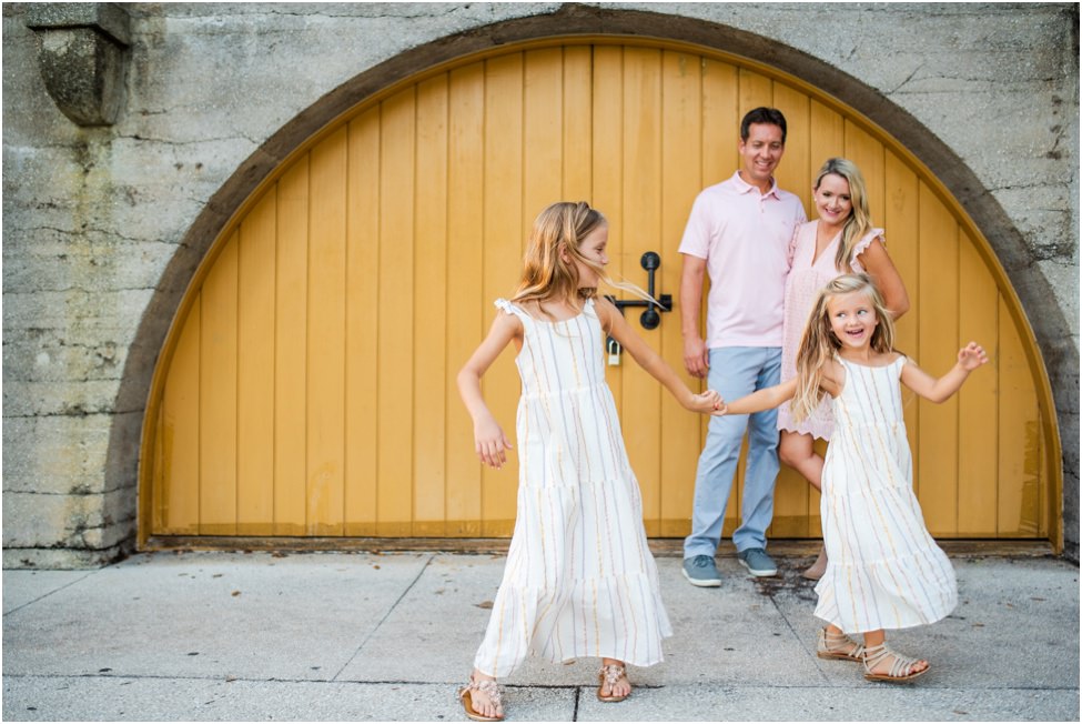 Parents smiling while children play and laugh in a family photoshoot in Jacksonville FL