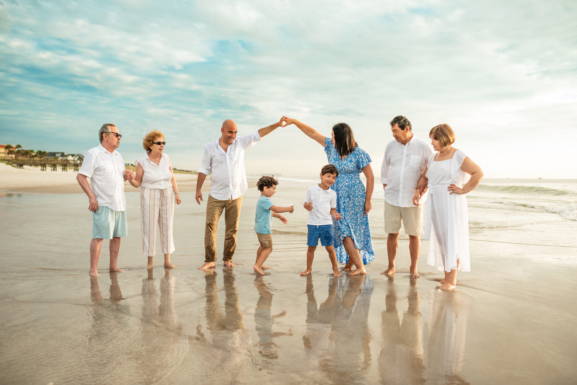 Family photo on the shore of the beach with two young children playing in a family photoshoot in Jacksonville FL