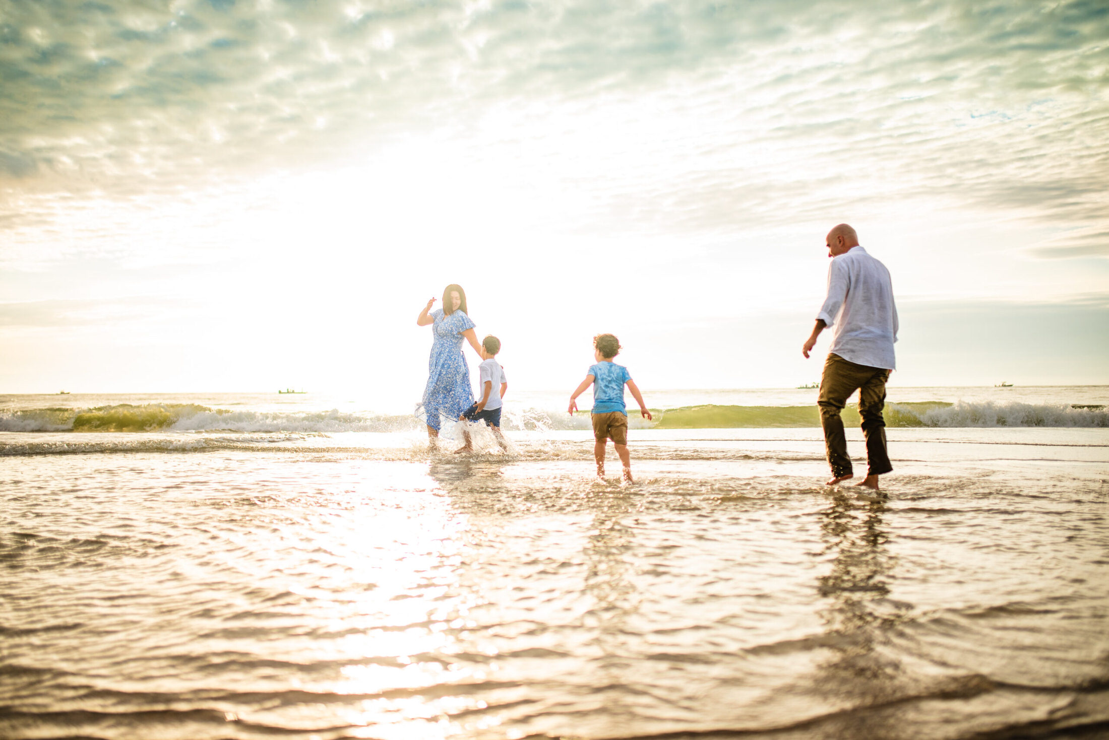 Parents and children playing on the beach shore in a family photoshoot in Jacksonville FL