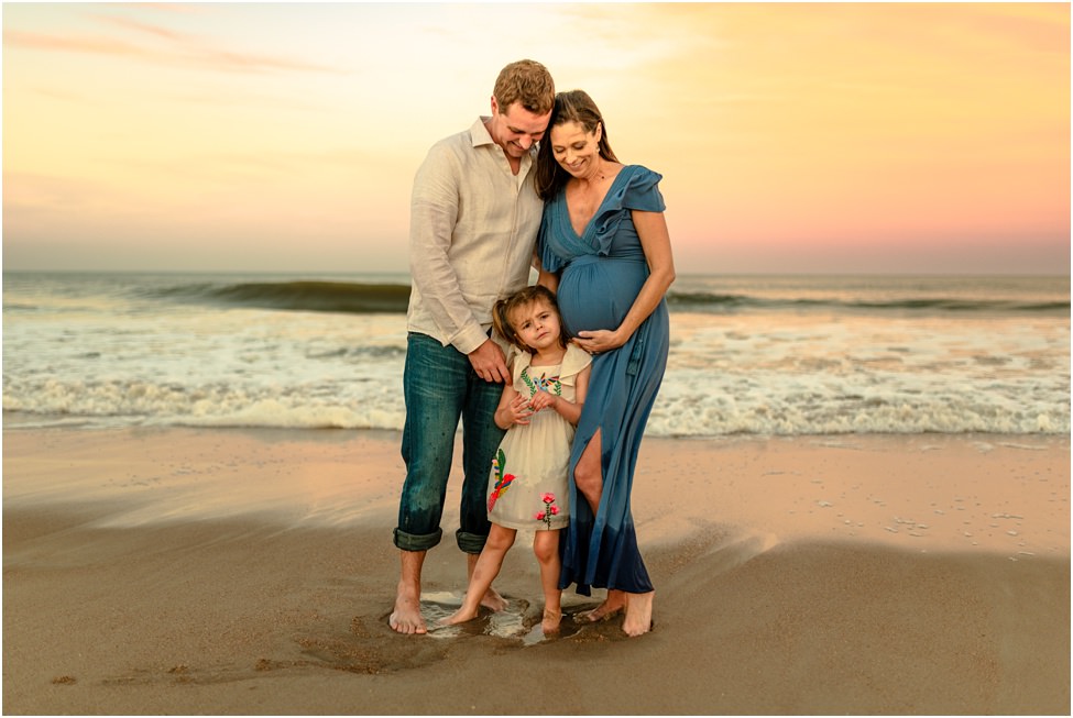 Parents and young child posing for a photo on the beach in a family photoshoot in Jacksonville FL