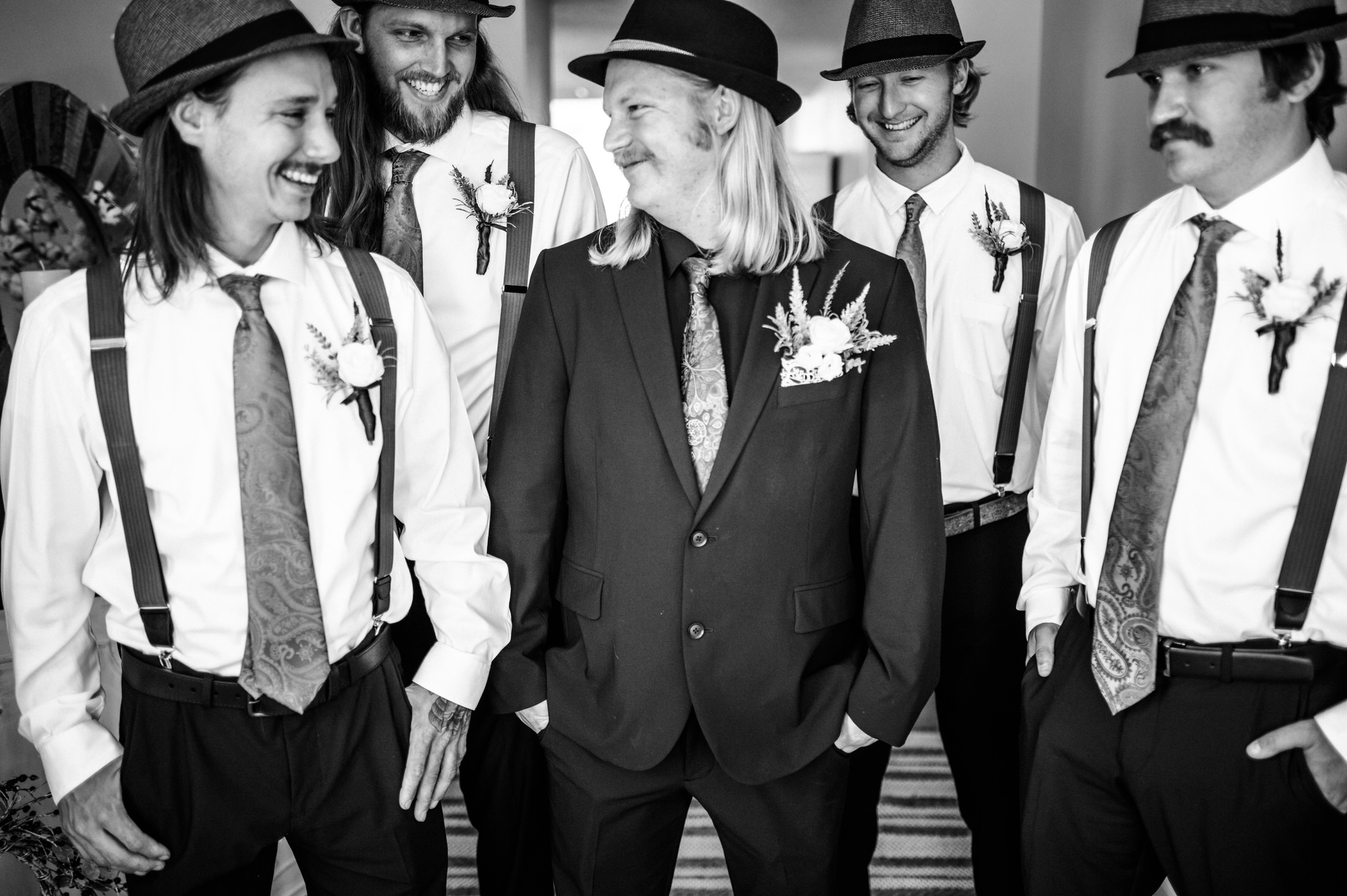 groomsman and groom smiling at each other in jacksonville couples photoshoot