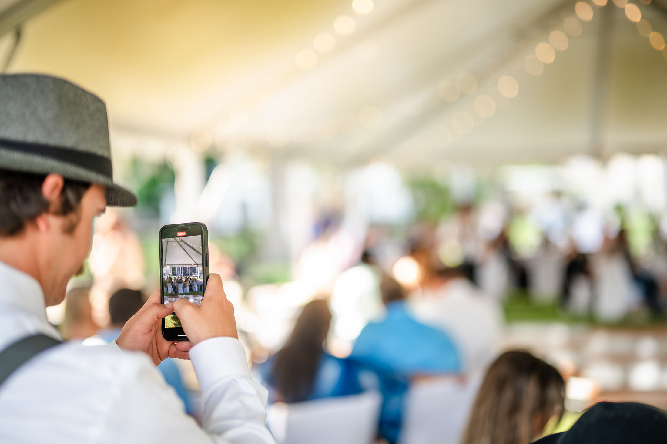 man taking picture on phone of wedding reception at jacksonville couples photoshoot