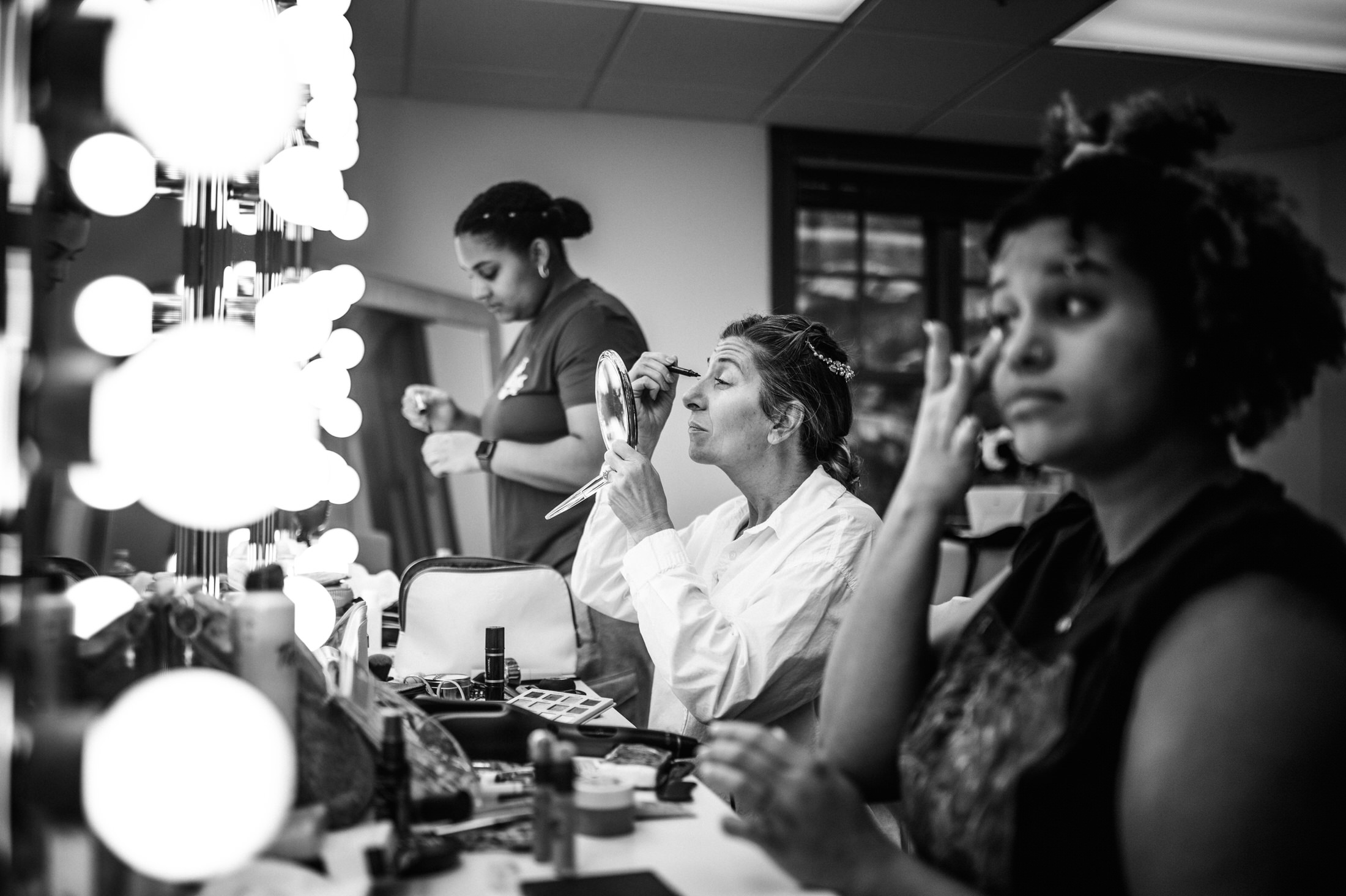 bride and bridesmaids getting ready doing makeup at a jacksonville wedding photoshoot