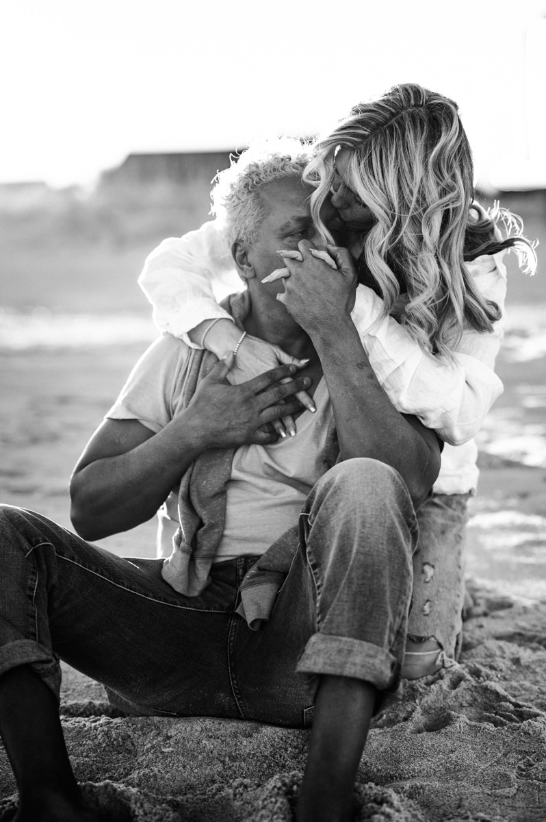couple holding hands and holding each other on the beach shore in a jacksonville couples photoshoot