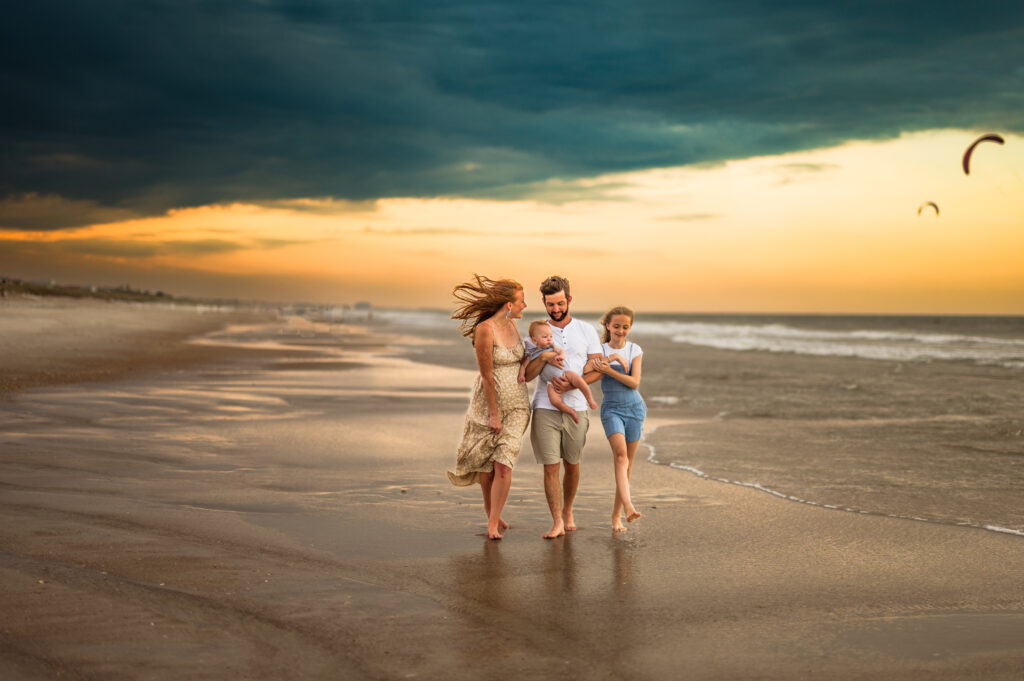 Family walking along beach shore at dusk in a family photoshoot in Jacksonville FL