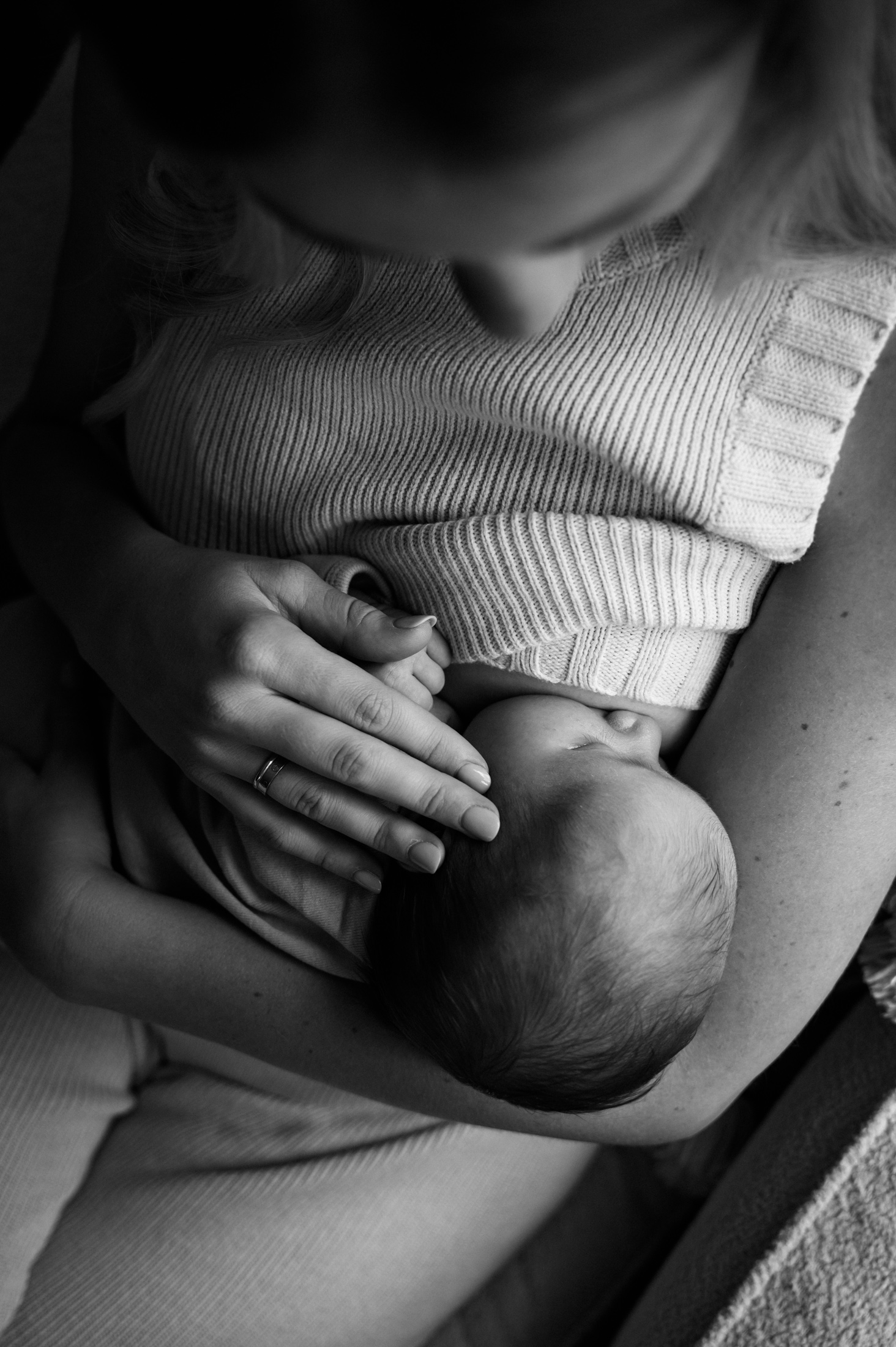Black and white low light portrait of mom nursing her new baby while at Jacksonville at home newborn session by Monika Colichio