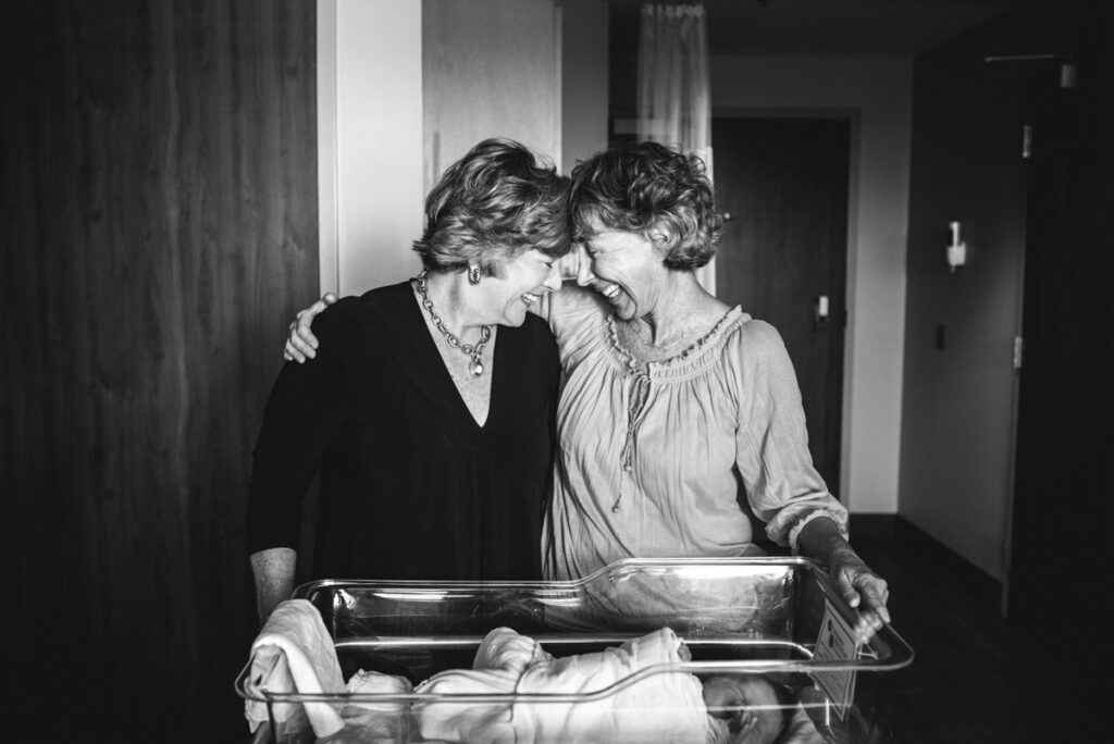 Sentimental black and white portrait of grandmas welcoming their grand baby in the hospital by Jacksonville newborn photographer
