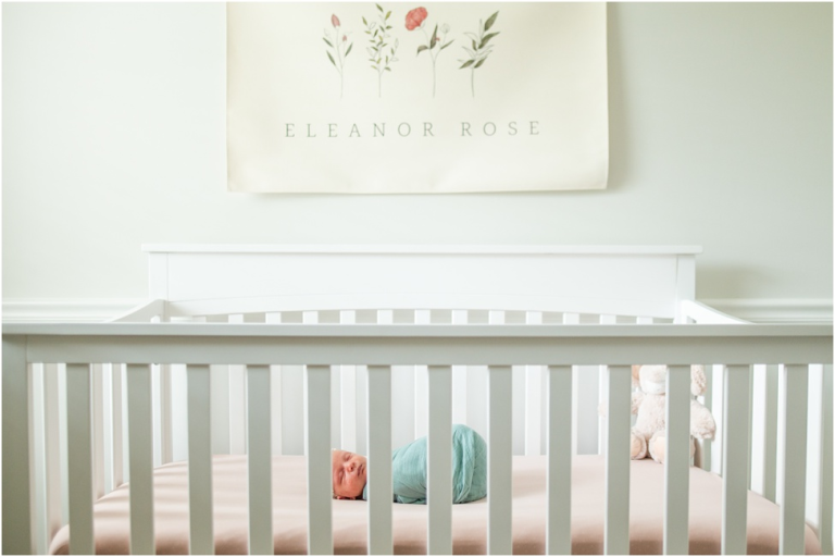 wide angle photo of Jacksonville newborn baby girl wrapped and sleeping in her crib